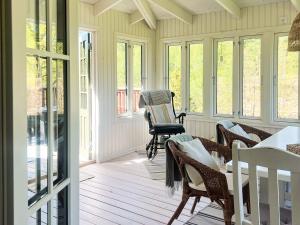 a screened in porch with chairs and a table at 5 person holiday home in Häradsbäck in Ryd