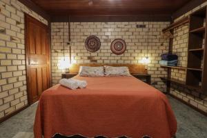 a bedroom with a bed with towels on it at Pousada Zululand in Guarda do Embaú