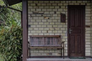 a wooden bench sitting in front of a brick house at Pousada Zululand in Guarda do Embaú