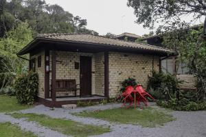 a small house with a red chair in front of it at Pousada Zululand in Guarda do Embaú