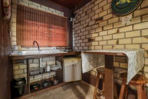 a small kitchen with a counter and a sink at Pousada Zululand in Guarda do Embaú