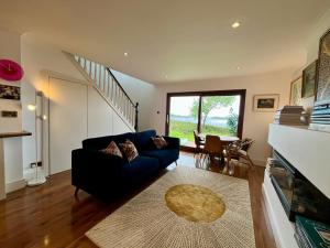 a living room with a blue couch and a staircase at 4 Harbour Town House in Westport