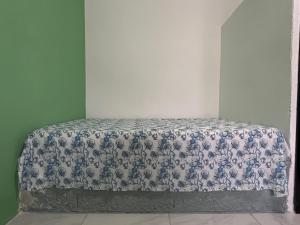 a bed with a blue and white bedspread in a room at Pousada Açaí in Ilha Comprida