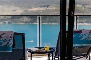 a glass of orange juice sitting on a chair on a balcony at Novi Hills Residence in Španjola