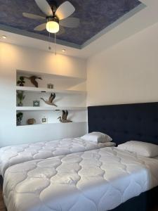 a bedroom with two beds and a ceiling at Archontarikia Luxury in Ouranoupoli +8 photos