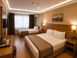a hotel room with two beds and a television at Prens Hotel Istanbul by GKRY Hotels Group - Tram And Metro Stops Are Just a Few Min Walk Away in Istanbul