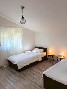 a bedroom with two beds and two tables with lamps at Ivano & Franko apartments in Kruševo