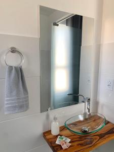 a bathroom with a glass sink and a mirror at Studio moderno com cozinha completa e Wi-Fi centro in Barbacena