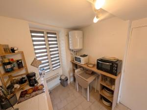 a small kitchen with a counter with a microwave at Charmant studio au centre de Gréoux-les-Bains in Gréoux-les-Bains +4 photos