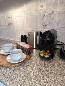 a kitchen counter with a coffee maker and cups and plates at Archontarikia Luxury in Ouranoupoli