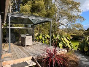 a wooden deck with a canopy in a garden at Awaroa Retreat in Whangarei