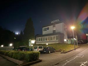 a hotel with cars parked in a parking lot at night at Wald Hotel in Kirschweiler