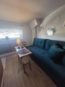 a living room with a blue couch and a table at Radiowa mini in Warsaw