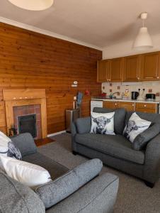 a living room with two couches and a fireplace at Scoor House - Cruachan in Bunessan