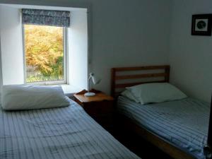 a bedroom with two beds and a window at Scoor House - Cruachan in Bunessan