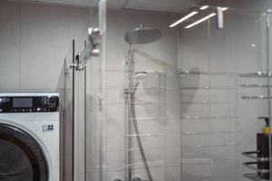 a shower in a bathroom next to a washing machine at Zviedru Nams in Liepāja +85 photos