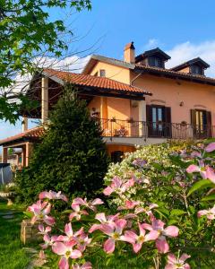 a house with pink flowers in front of it at Orto del pettirosso Appartamento con piscina privata e BBQ in Front