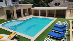 a large swimming pool with chairs and a building at Imani staycations Diani in Diani Beach