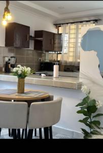 a kitchen with a table and chairs and a kitchen with a counter at Imani staycations Diani in Diani Beach