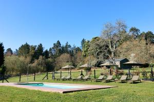 a group of chairs sitting next to a swimming pool at Casas do Campo in Monfero