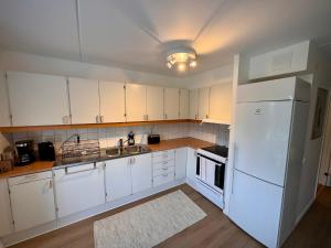 a kitchen with white cabinets and a white refrigerator at Falkenbergsvägen 1C, Ullared in Ullared