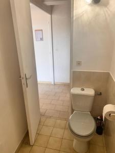 a bathroom with a white toilet and a door at Charmant studio au centre de Gréoux-les-Bains in Gréoux-les-Bains