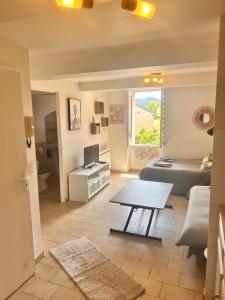 a living room with a bed and a table at Charmant studio au centre de Gréoux-les-Bains in Gréoux-les-Bains