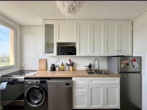 a kitchen with white cabinets and a washer and a sink at Paris Appartement 2-pièce Master Bedroom Romantique in Alfortville