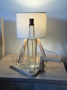 a bottle and glasses on a table with a lamp at Mont in Rudnik