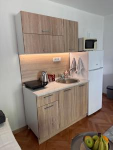 a small kitchen with a sink and a refrigerator at Mont in Rudnik