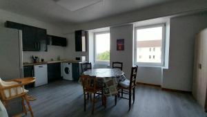 a kitchen and dining room with a table and chairs at 50 nuances de couleurs in Arinthod