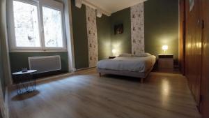 a bedroom with a bed and a large window at 50 nuances de couleurs in Arinthod