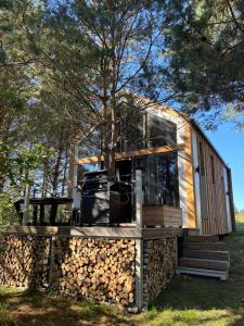 a tiny house on a pile of logs at Domki Wieck in Czarna Woda