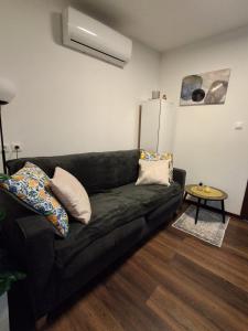 a living room with a black couch and a table at Apartment Allapera in Svibovec Podravski