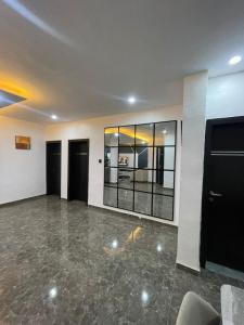 a large empty room with black doors and marble floors at Kayus Place in Isaga-Abosule