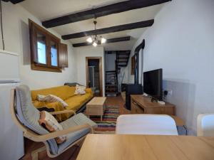 a living room with a yellow couch and a table at Acogedora casa en Pampaneira in Pampaneira +6 photos