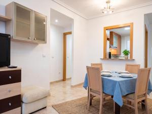 a dining room with a blue table and chairs at Jardines del mar III-2ª linea de playa Piscina y Parking Ideal familias Marina d'Or in El Borseral