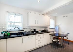 a kitchen with white cabinets and a small table at The Clubhouse in Sheffield
