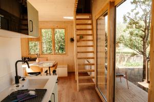 a tiny house with a staircase in a kitchen at Mokuzo Tiny Houses in Lauingen