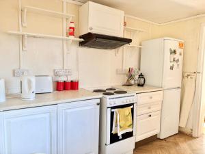 a kitchen with white cabinets and a stove and refrigerator at Smart Double Room in Reading