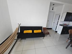 a black couch with two yellow pillows in a living room at Modern AC Excellent location in Los Jocotes