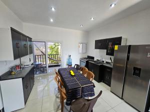 a kitchen with a table with chairs and a refrigerator at Modern AC Excellent location in Los Jocotes