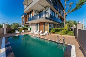 a house with a swimming pool in front of a building at VISTA SERENA Ermenek in Altınkum