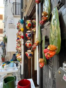 a wall with many vases hanging on a building at La Steila del Sud in Polignano a Mare
