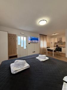 a bedroom with two white towels on a bed at Apartments & Rooms Prižmić in Podstrana
