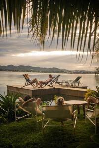 a group of people laying in chairs on a dock at Samaya Wellness Lodge in Flores