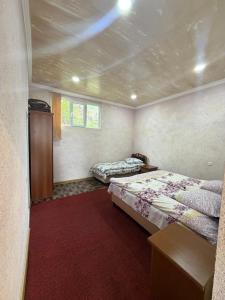 a bedroom with two beds and a red carpet at Saro B&B in Tatev in Tandzatapʼ