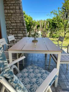 a wooden table and chairs on a patio at Kősüllő Vendégház in Szántód