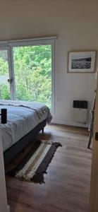 a bedroom with a bed and a large window at Kattyjaus in San Carlos de Bariloche