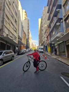 a person is holding a bike in the street at Quarto Duplo, até 2 pessoas in Porto Alegre